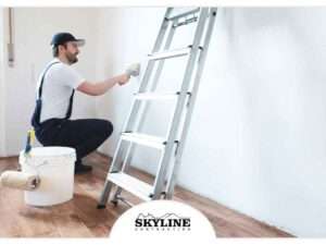 interior painter with ladder leaning against a white wall