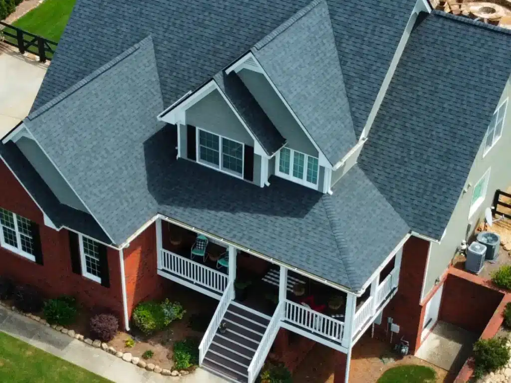 Aerial view of a completed asphalt roof restoration on a brick home, part of the roof repair process by Skyline Contracting