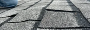 An aerial view of a roof with missing shingles, showing damage that requires a cost-effective roof repair from Skyline Contracting