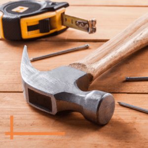 hammer and tape measure laying on top of deck boards close up