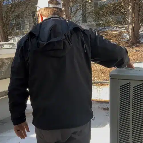 Roofer completing rooftop inspection near HVAC unit as part of comprehensive metal roof repair by Skyline Contracting in GA