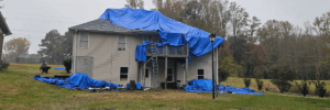 Storm-damaged home with roof tarps showing weather impacts on roofing by Skyline Contracting in Gainesville