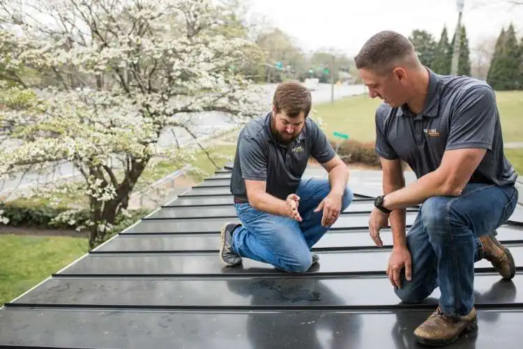 two slc roof inspectors on a flat metal roof