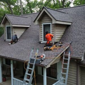 Certified roofing specialists contractor on a brown roof in a process of roof replacement in Gainesville, GA