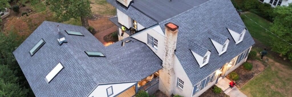 Aerial view of a house with grey roof and white siding by roof installation company in Gainesville, GA