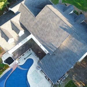 House with grey roof and a swimming pool in the backyard that had a roof replacement by certified roofing specialists in Gainesville, GA