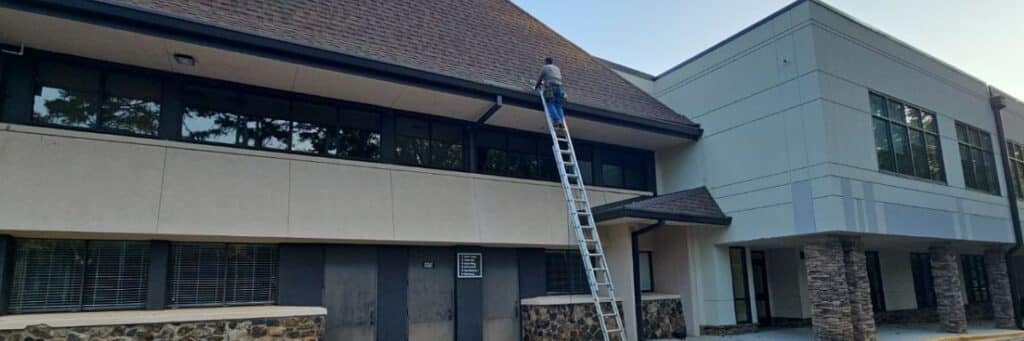 Skyline Contracting tea member on top of a ladder in a process of commercial roofing services in Gainesville