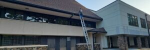 Skyline Contracting tea member on top of a ladder in a process of commercial roofing services in Gainesville