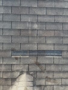 Gray asphalt shingles with visible repair patch, warranty‑covered roofing services in Gainesville, GA by Skyline Contracting