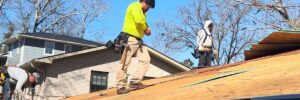 A group of roofing contractors on top of a roof in a process of roof replacement in Gainesville, GA