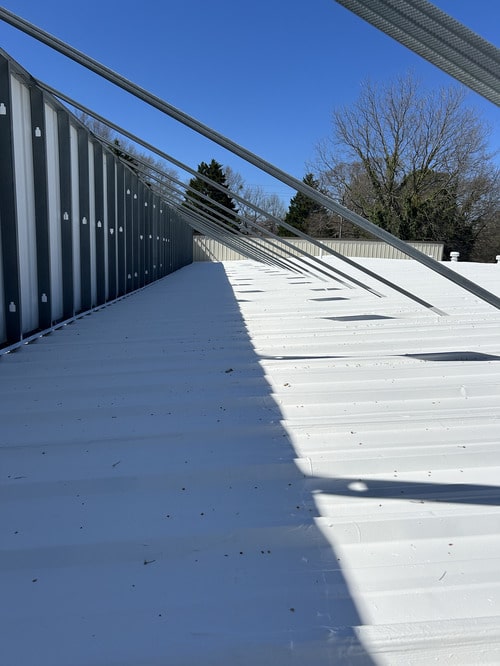 GAF acrylic roof coating being sprayed onto building rooftop