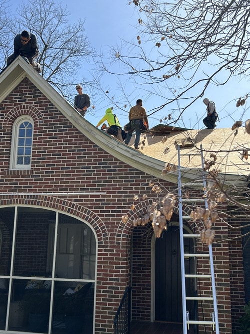 Skyline Contracting team removing old roofing materials on historic home