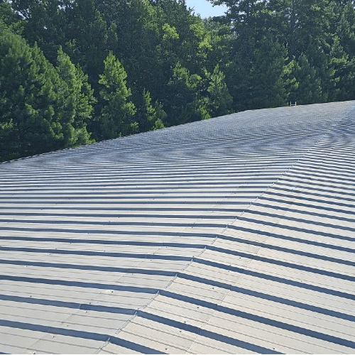 Metal roof installation in progress with visible underlayment
