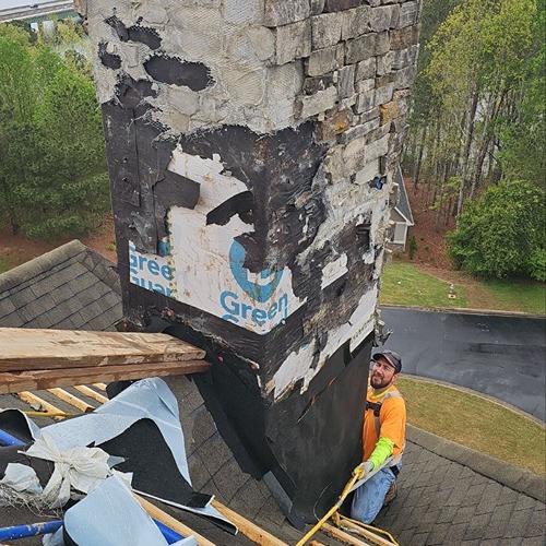 Roofer repairing chimney during steep roof replacement and chimney restoration by Skyline Roofing Company in Lake Lanier