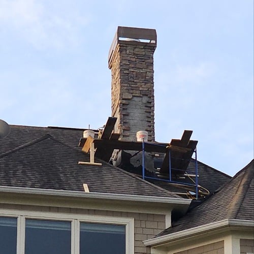 Chimney replacement in progress on home roof by Skyline Roofing Company in Lake Lanier