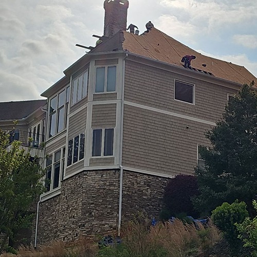 Ongoing roof repair on a steep residential roof by Skyline Roofing Company in Lake Lanier