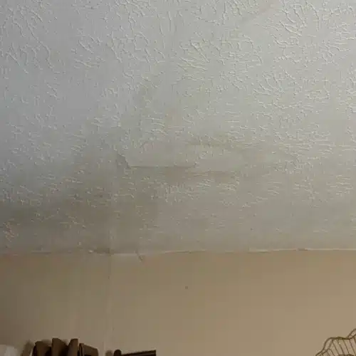 Interior ceiling with visible water stains and discoloration, highlighting signs you need a new roof, water stains on the ceiling, and moisture issues