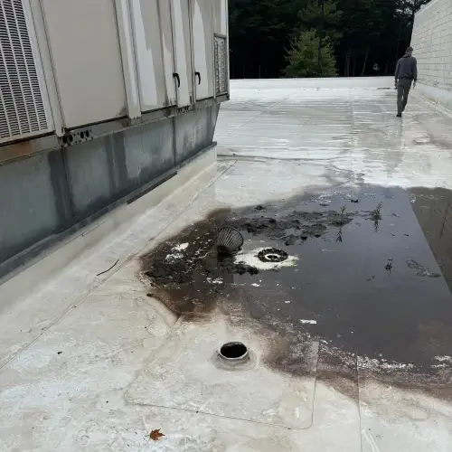 Standing water and drainage issue on commercial flat roof showing signs of leak damage, highlighting roof leak repair cost factors managed by Skyline Contracting