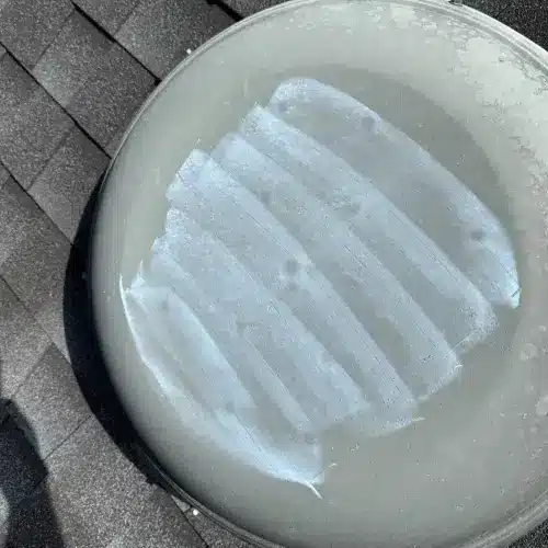 Close-up inspection of roof damage for roof insurance claim documentation by Skyline Contracting