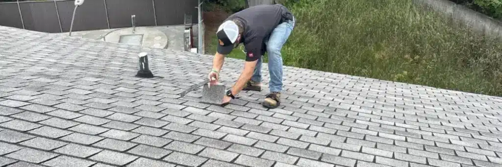 Roofer installing natural slate tiles on a residential roof, demonstrating the durability and beauty of slate roofing by Skyline Contracting.