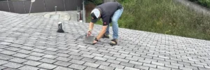 Roofer installing natural slate tiles on a residential roof, demonstrating the durability and beauty of slate roofing by Skyline Contracting.