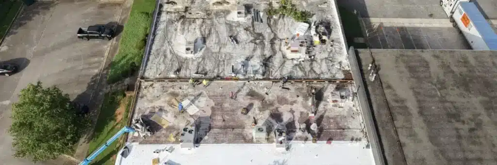 Roofing crew performing commercial flat roof repair with professional tools and safety gear by Skyline Contracting