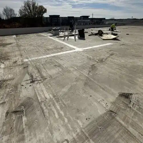 Crew performing commercial flat roof repair on a large building with professional roofing materials by Skyline Contracting