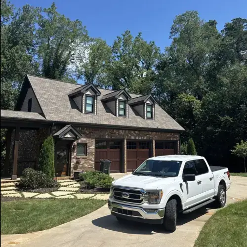 Home with slate roof showcasing durability and aesthetic appeal with a Skyline Contracting work truck in driveway