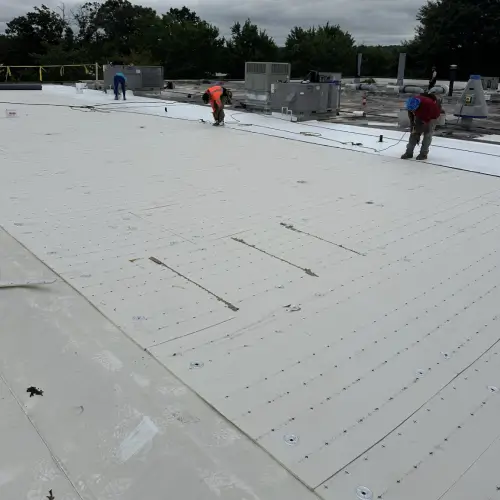Technician repairing a commercial flat roof using professional tools and materials by Skyline Contracting