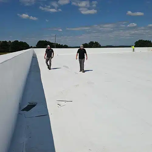Roof inspectors performing a visual inspection and safety check on a flat commercial roof by Skyline Contracting in Gainesville, GA