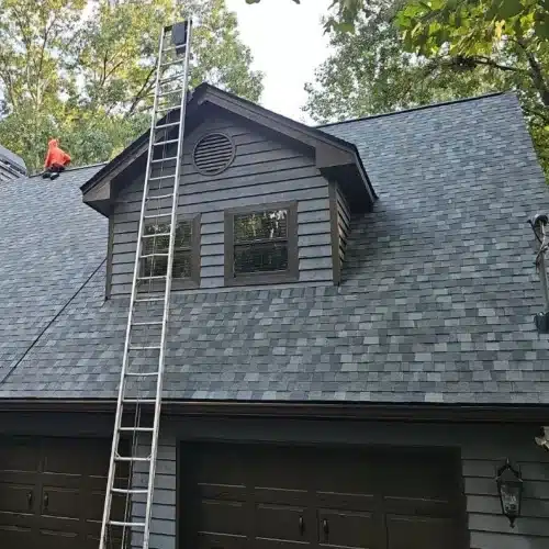 New architectural shingles on gray home ladder set for final inspection what to expect during a roof replacement by Skyline Contracting in Gainesville