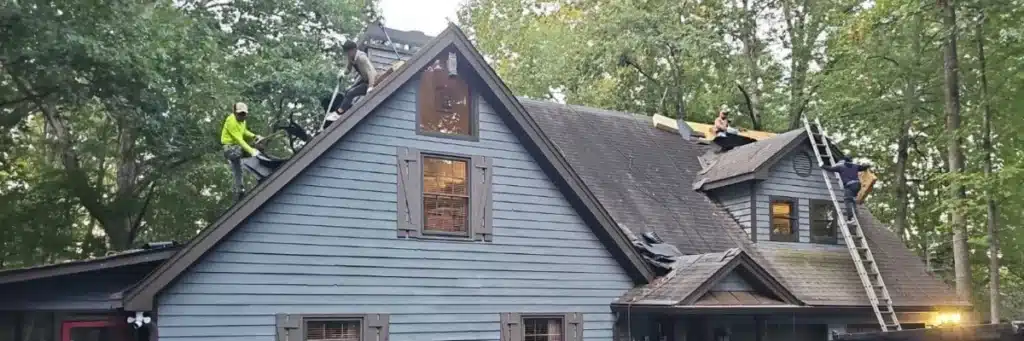 Crew removing old shingles on gable roof what to expect during a roof replacement by Skyline Contracting in Gainesville