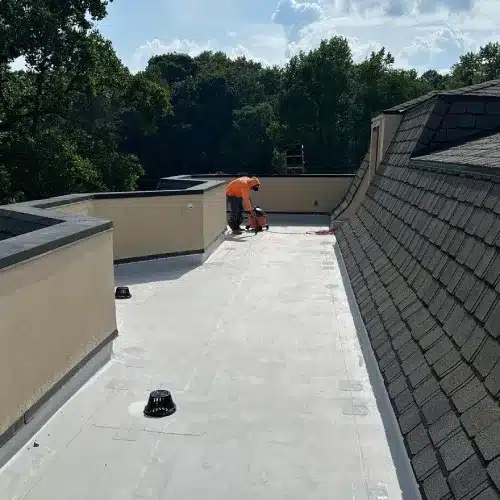 A roofing contractor walking on a durable flat roof surface during a routine inspection by Skyline Contracting | Roofing Contractor & Remodeler in GA
