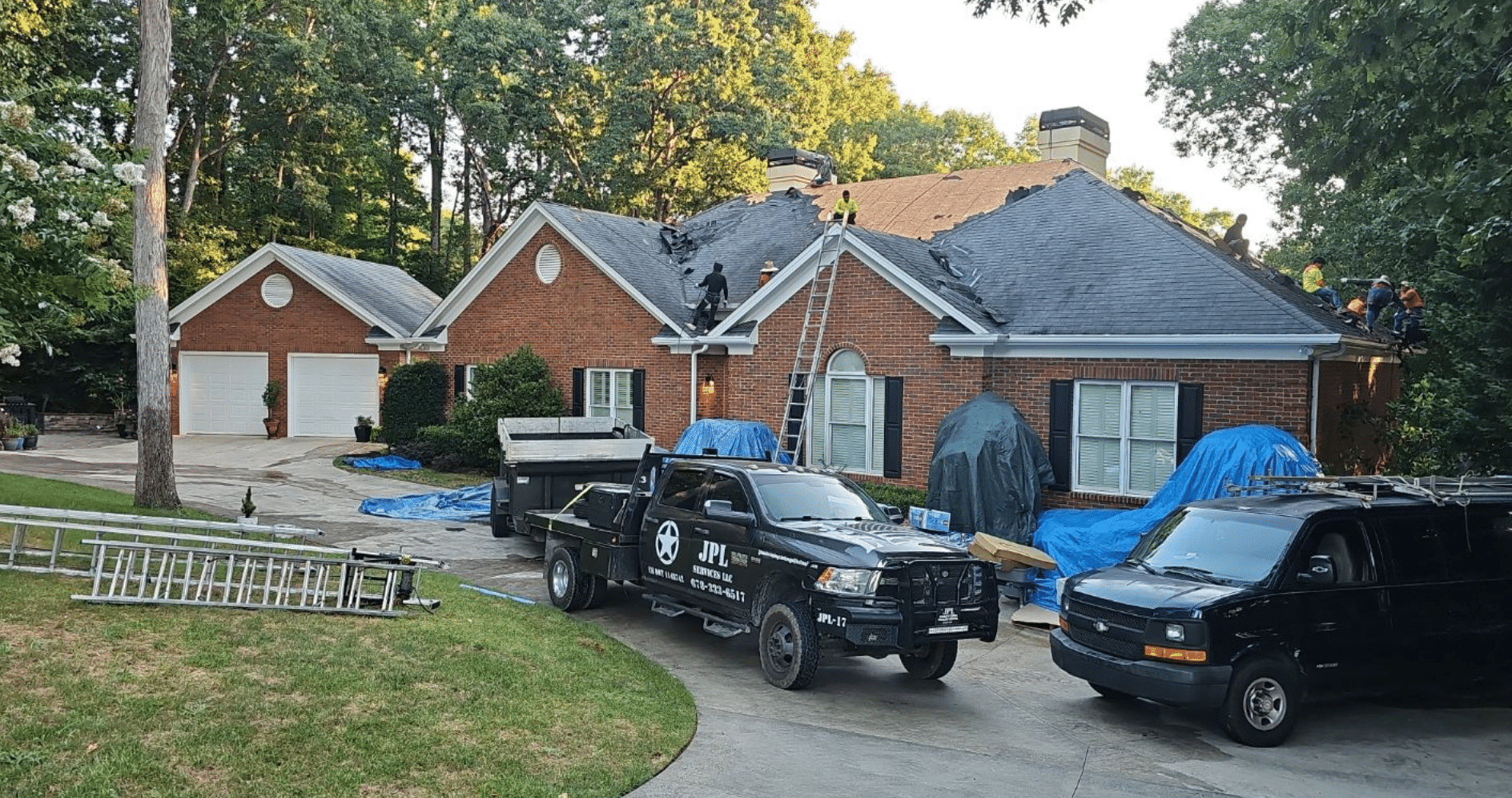 Roofers replacing shingles on a large home, supporting questions to ask a roofing contractor in Gainesville by Skyline Contracting.