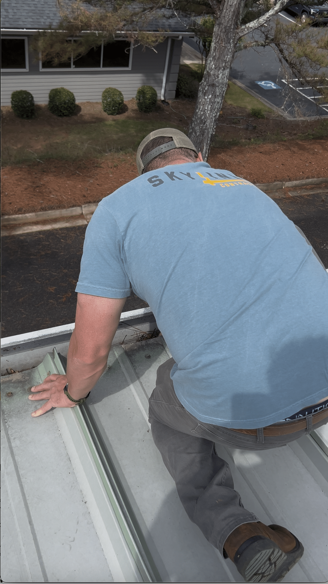 A roofer inspecting a roof edge during spring roof maintenance in Gainesville by Skyline Contracting