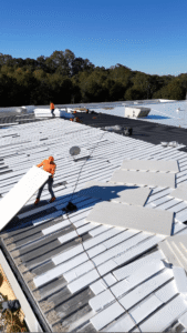Roofing crew installing insulated roof panels on a commercial building highlighting NDL warranty benefits in Gainesville, Georgia by Skyline Contracting
