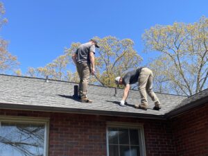 Two roofers inspecting shingles during a roof check, supporting questions to ask a roofing contractor in Gainesville by Skyline Contracting.