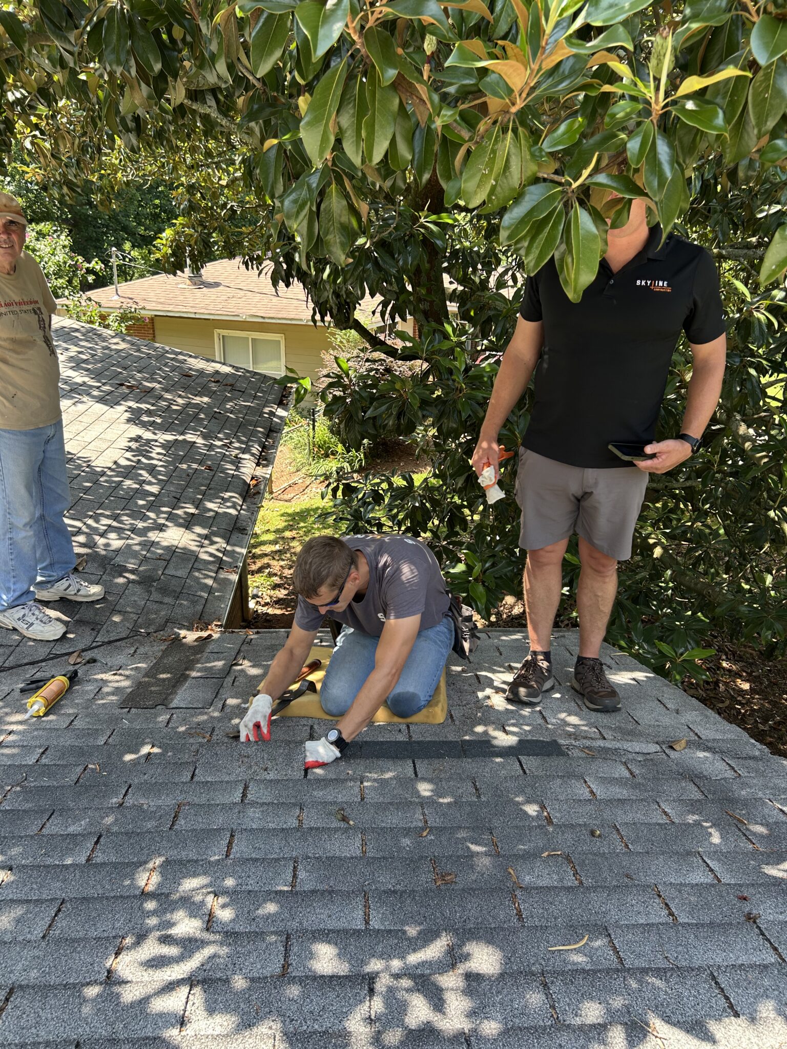 A Skyline Contracting team member kneeling on a residential roof to meticulously align and secure a new asphalt shingle as part of a proactive roofing maintenance checklist roofing service in Gainesville by Skyline Contracting