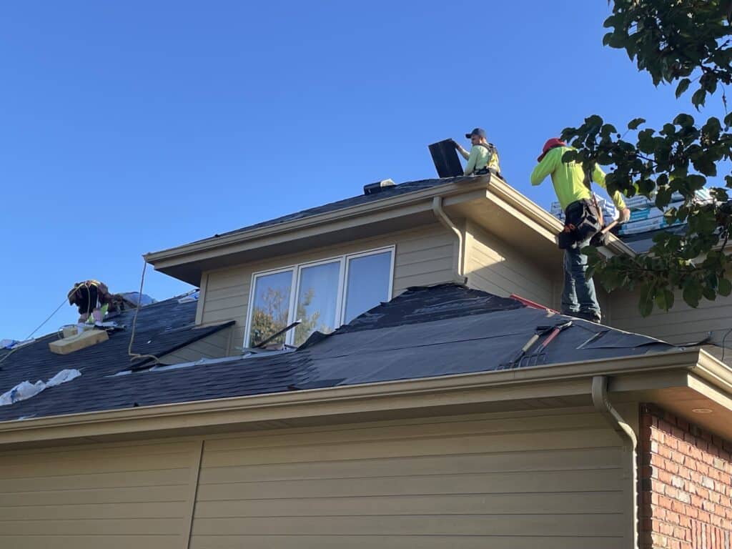 Roofing crew applying protective underlayment and shingles before winter weather as part of fall roofing tips residential roof replacement in Omaha by Anchor Roofing