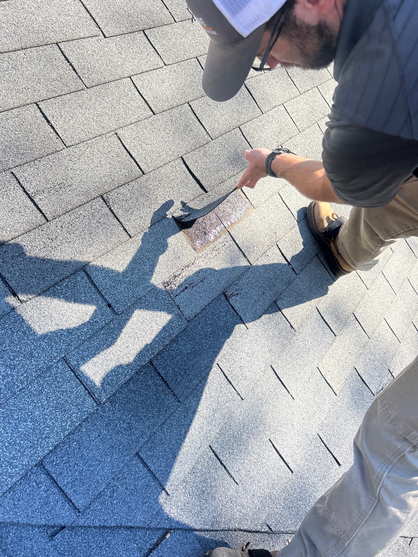 Skyline Inspector lifting torn shingle following a hail damage roof guide inspection in Gainesville, GA by Skyline Contracting