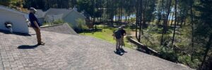 Skyline Contracting crew on a finished shingle roof at a lakeside home, GAF master certified contractor roofing in Gainesville, GA by Skyline Contracting